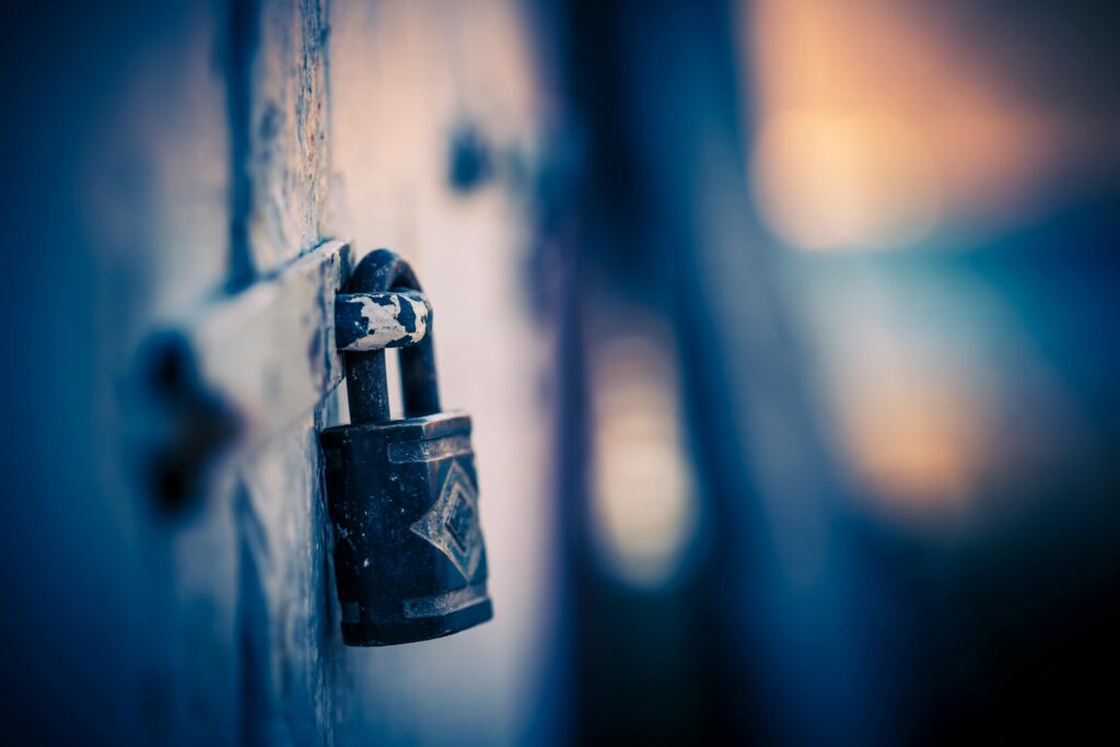 Close-up of a rusty padlock against blurred background lights. Artistic bokeh effect.